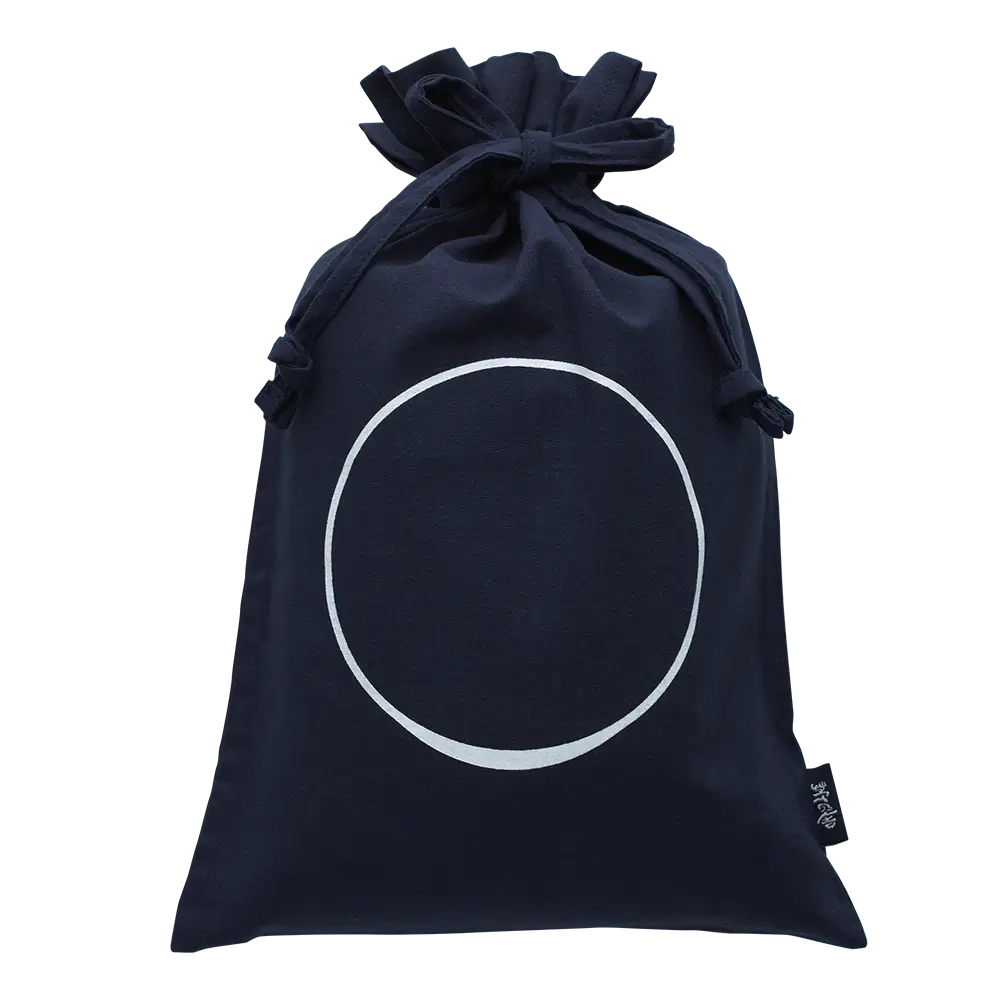 The Custom Umami Gift Bag - Medium by Kayanoya USA features dark blue organic cotton, a large white circle on the front, and a small black tag on the right side. The bag is displayed against a plain white background.