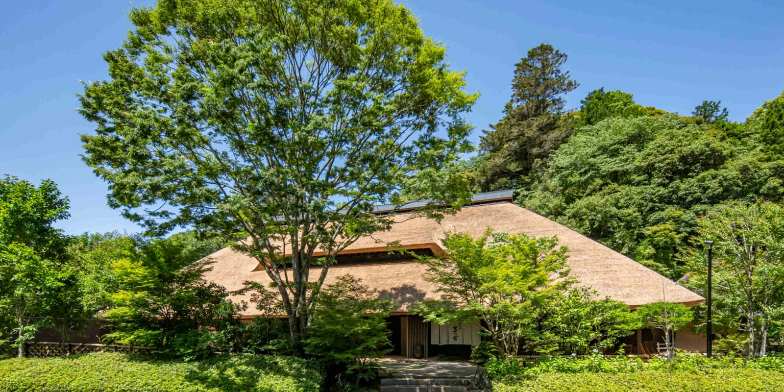 Kayanoya Restaurant surrounded by lush greenery beneath its newly re-thatched roof.