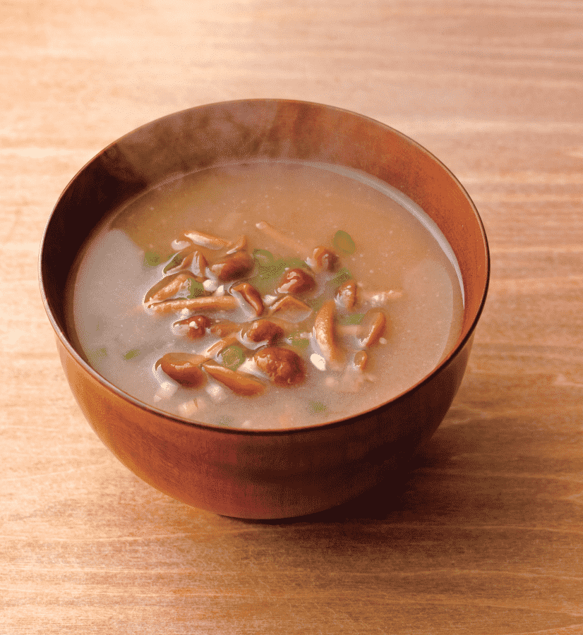 Steaming nameko mushroom miso soup served in a traditional wooden bowl.