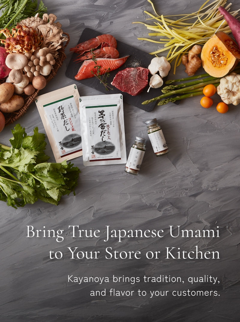 An assortment of fresh vegetables, mushrooms, seafood, and Kayanoya Japanese seasoning products are artfully arranged on a gray surface, with text promoting authentic Japanese umami for stores or kitchens.