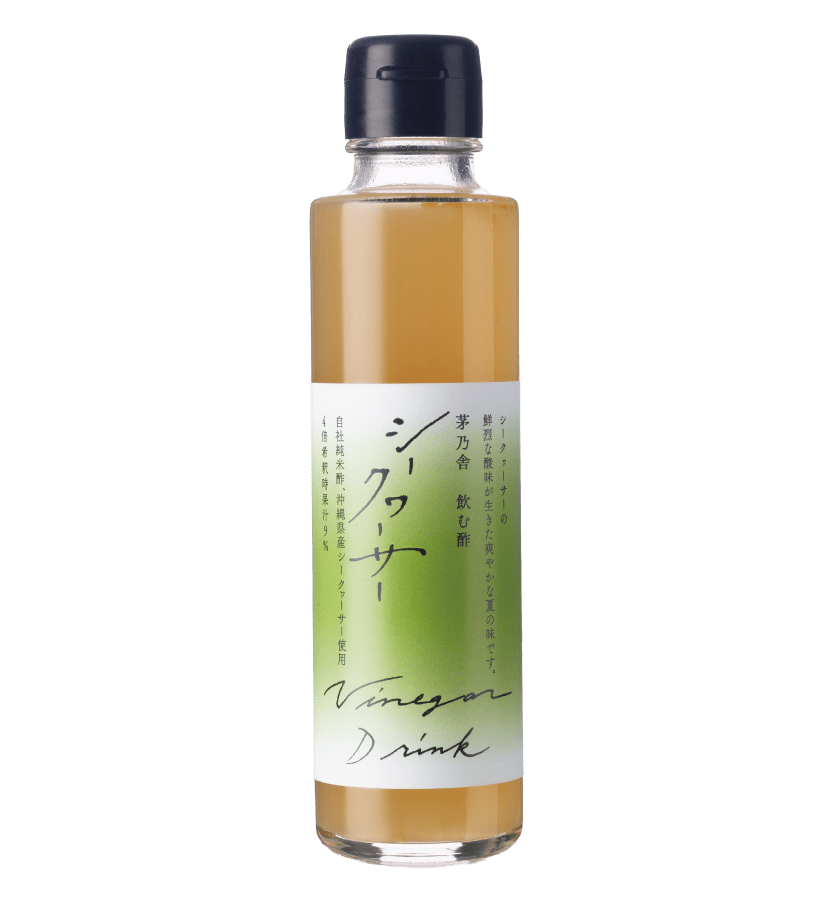 A clear glass bottle with a black cap contains Kayanoya USA's [Seasonal] Vinegar Drink Concentrate - Shikuwasa (150 ml), a light brown Okinawan citrus drinking vinegar. The green and white label features Japanese text and “Vinegar Drink.”.