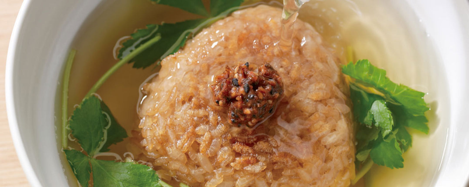 Crispy rice ball in dashi broth topped with red pepper and herbs