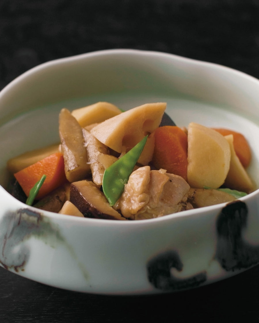 Simmered Japanese vegetables featuring lotus root, carrot, burdock root, shiitake mushroom, and chicken, gently braised in a light soy-based dashi broth and garnished with snow peas.