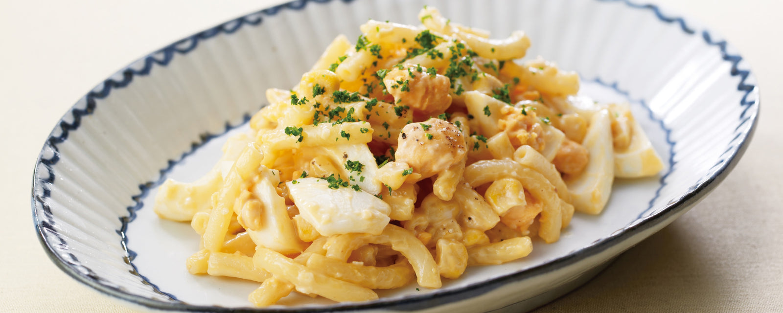 Macaroni and cheese dish with herbs on a decorative plate