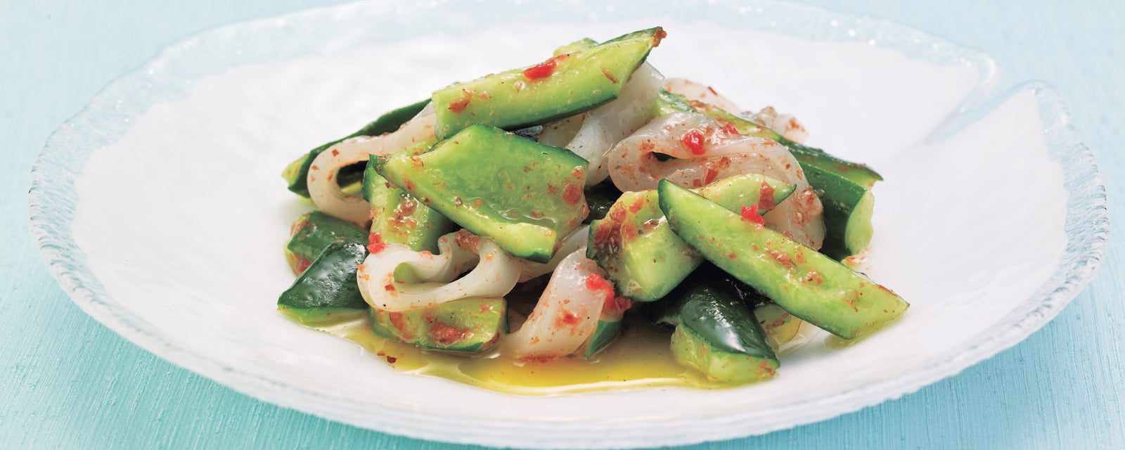 Ume-marinated squid and cucumber served on a white plate.
