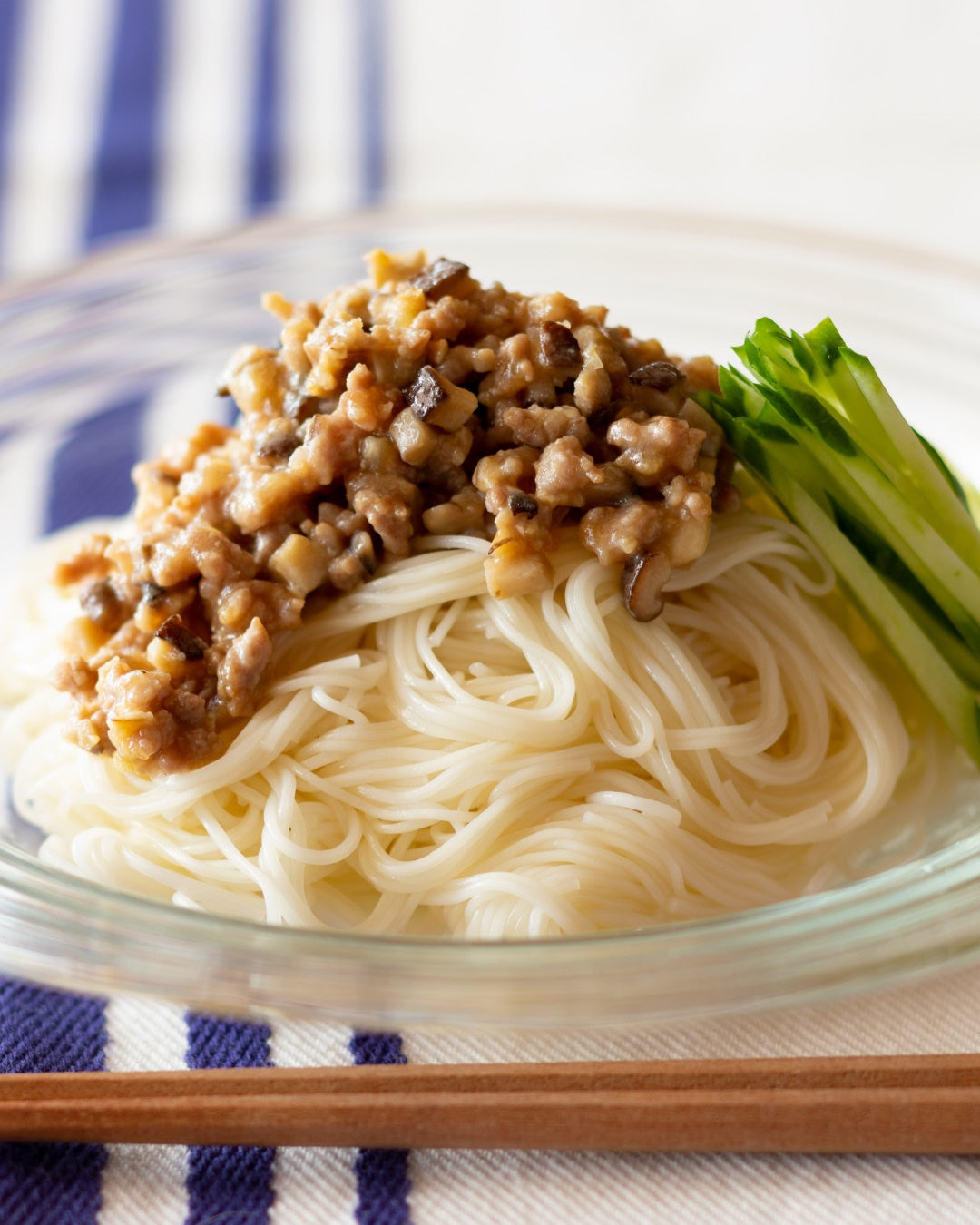 A bowl of zhajiang-style somen noodles topped with minced meat sauce and sliced cucumber.