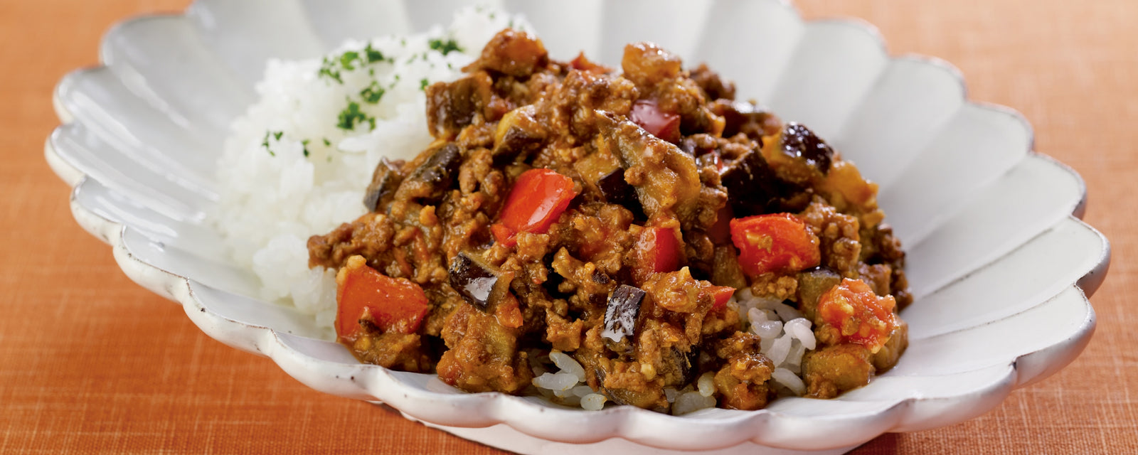A plate of Japanese dry curry with minced meat and vegetables served over steamed rice.
