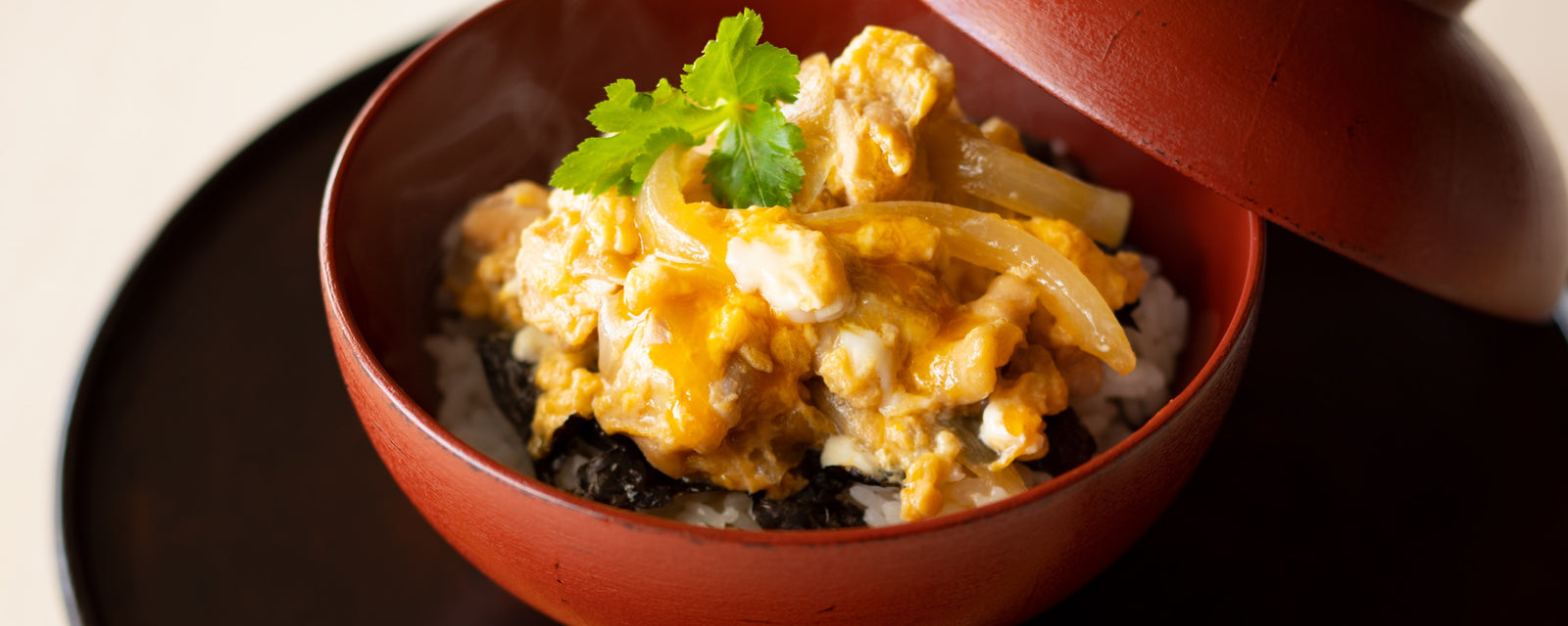 Oyakodon, a Japanese chicken and egg rice bowl, served in a wooden bowl.