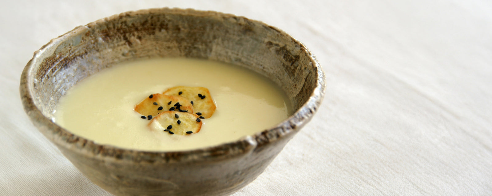 Creamy sweet potato potage topped with crispy sweet potato slices and black sesame.