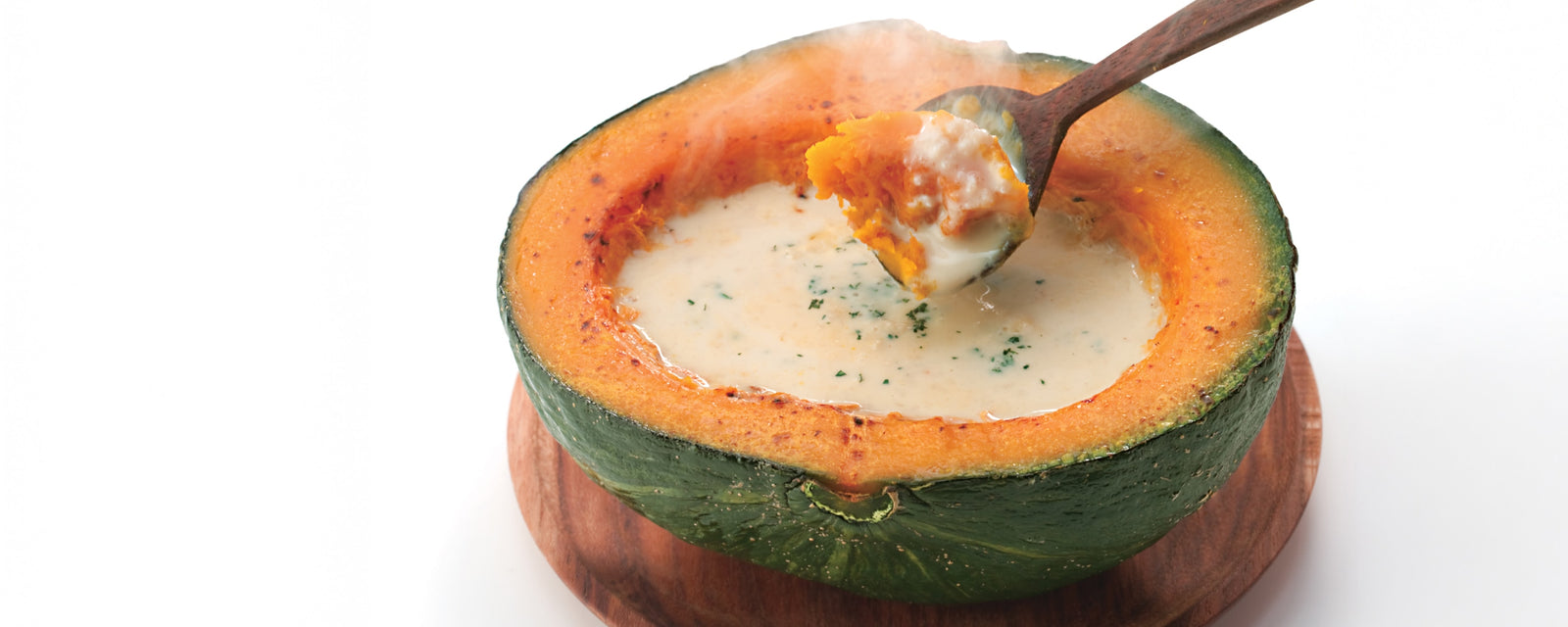 Pumpkin gratin soup served inside a roasted pumpkin.