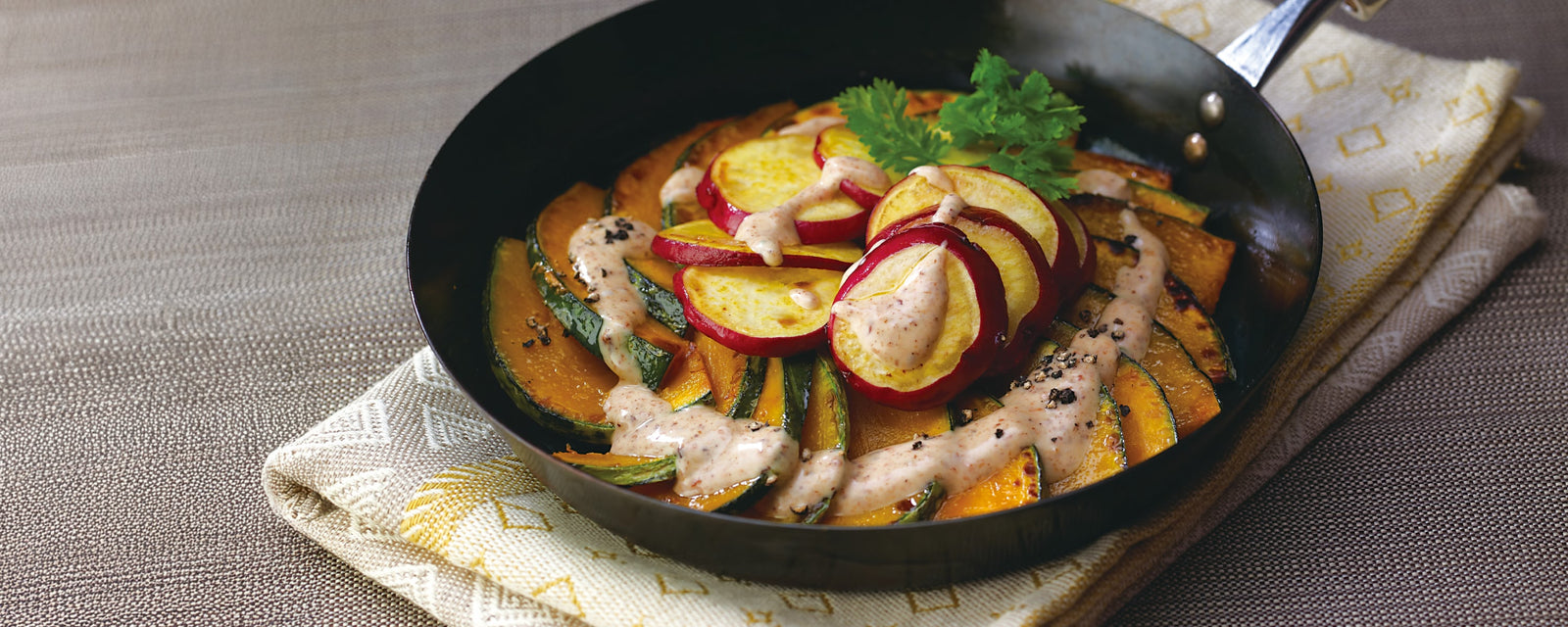 Grilled vegetable salad with squash and apples served in a skillet.