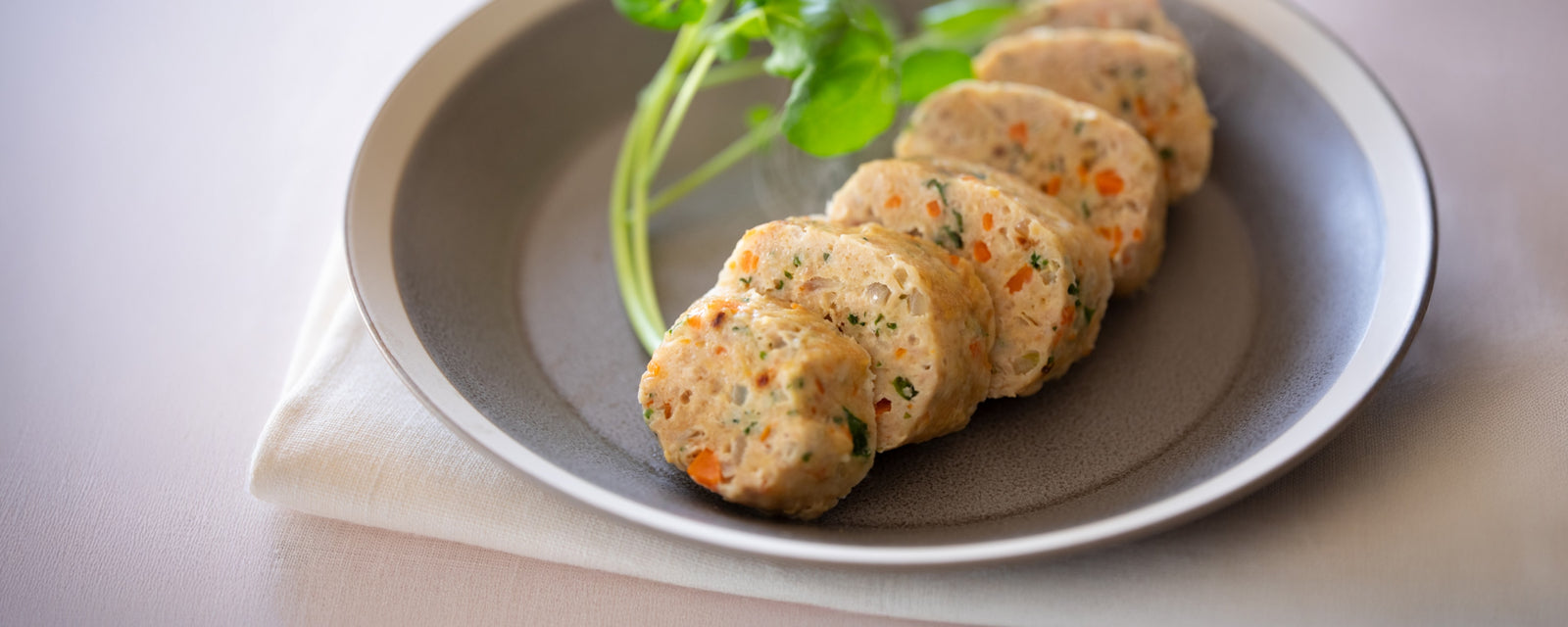 Sliced chicken meatloaf with vegetables served on a plate.