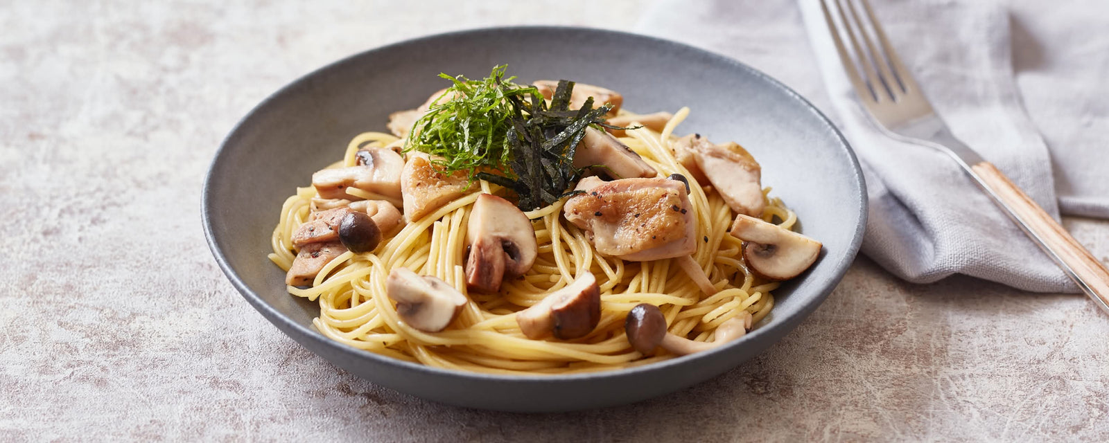 Spaghetti with sautéed chicken, mushrooms, and shredded nori garnish