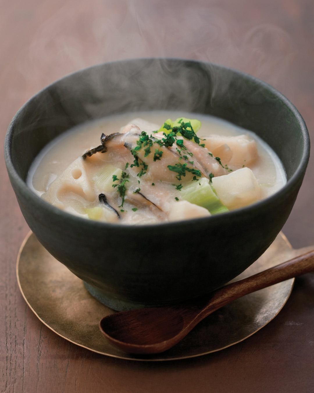 Steaming winter chowder with oysters and root vegetables served in a ceramic bowl.