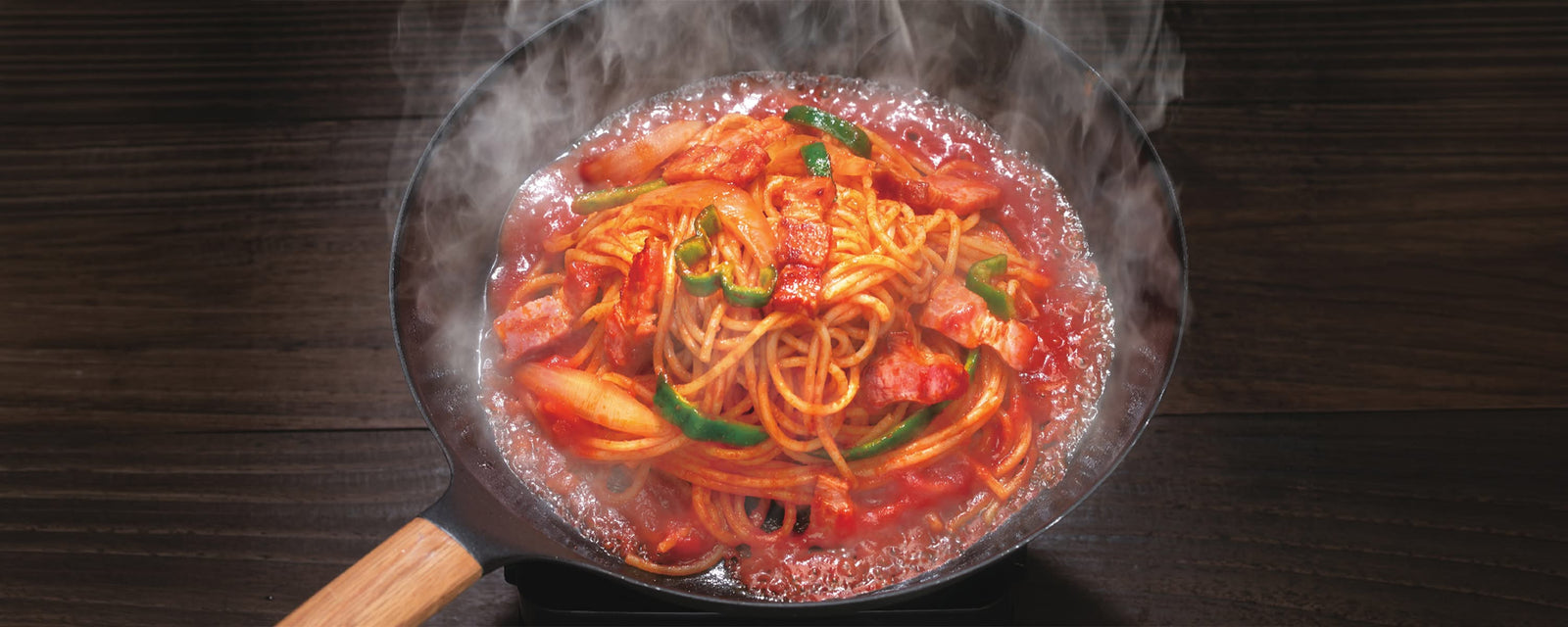 Glossy Spaghetti Napolitan with thick bacon, peppers, and onions in a tomato ketchup sauce.