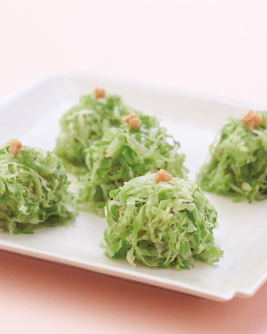Vibrant green cabbage-wrapped shumai dumplings with Japanese mustard.