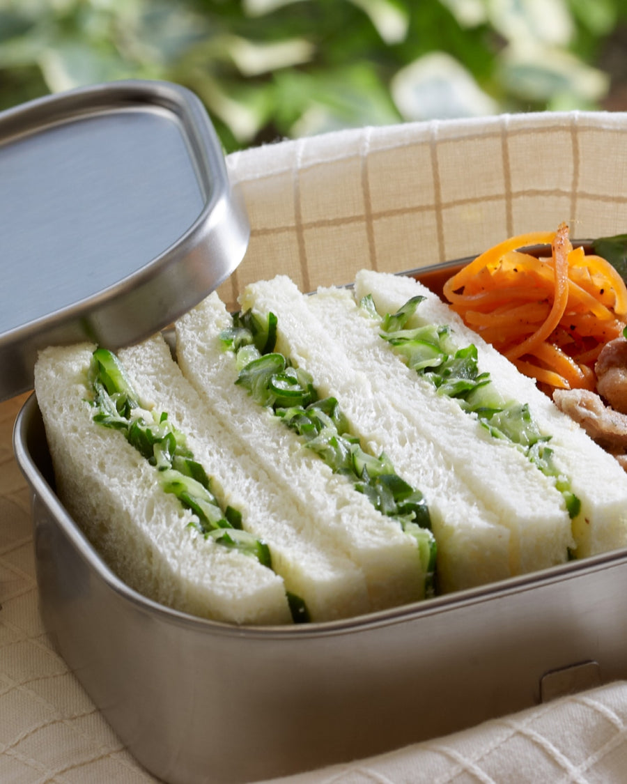 Japanese cucumber sandwich bento with soft white bread, fresh vegetables, and a warm soup on the side
