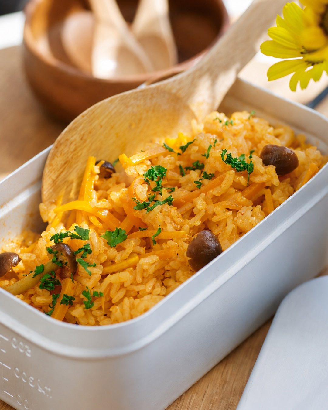 Rice dish with vegetables in a white container with a wooden spoon