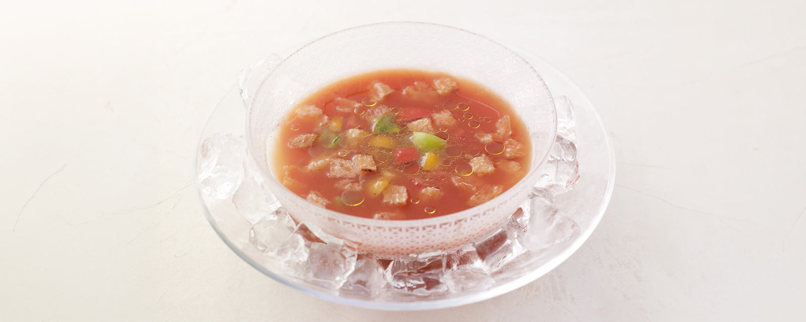 Chilled tomato gazpacho topped with cherry tomatoes and toasted bread, served over ice
