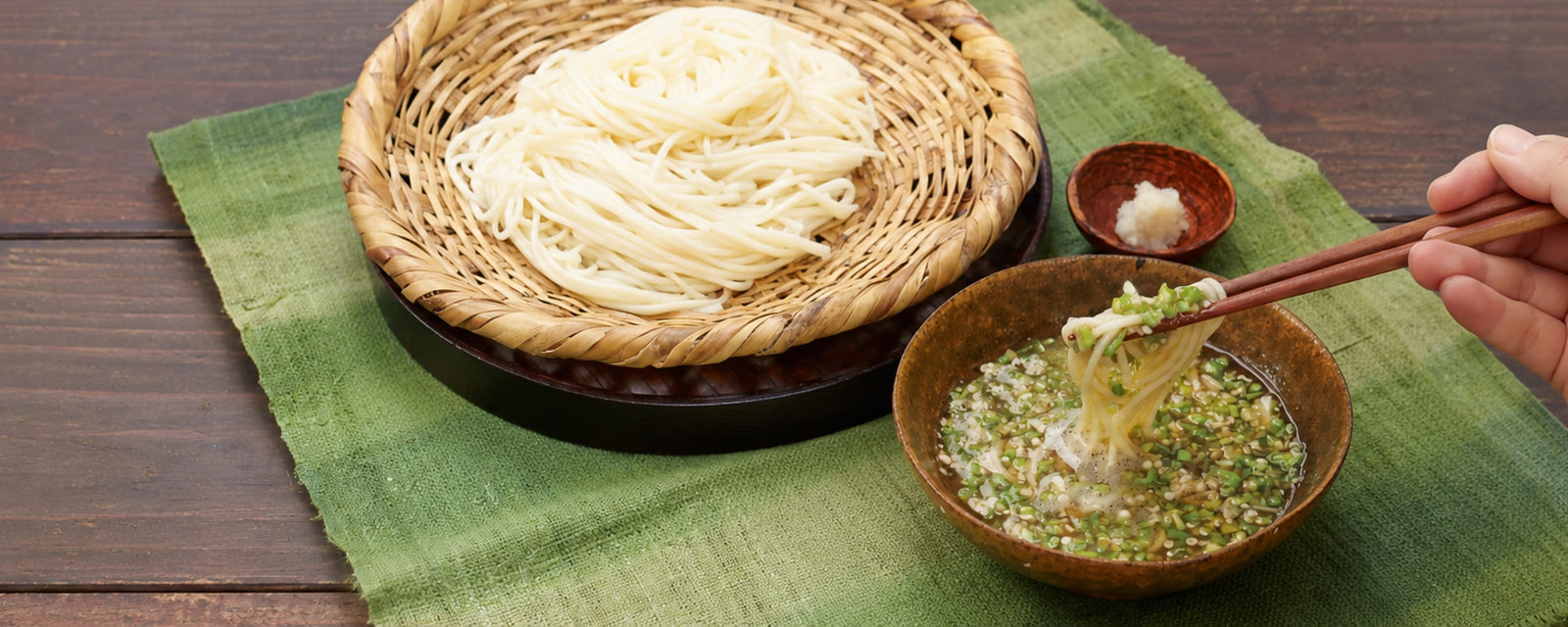 Chilled udon noodles served with a warm kombu dashi dipping broth made with okra and grated nagaimo, garnished with chopped green onions and grated ginger.
