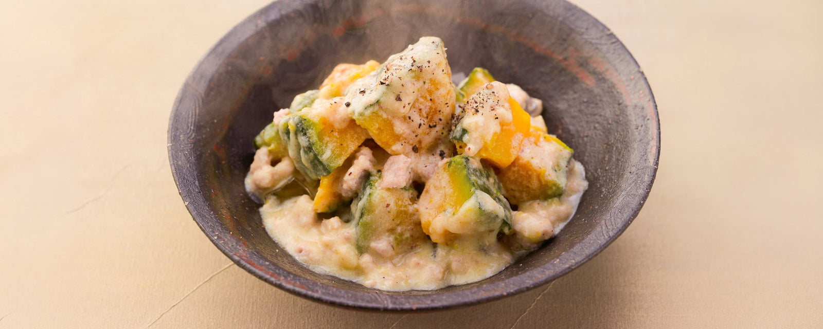 Simmered Pumpkin with Dashi and Cheese made with ground chicken and Kayanoya Original Dashi, topped with black pepper.