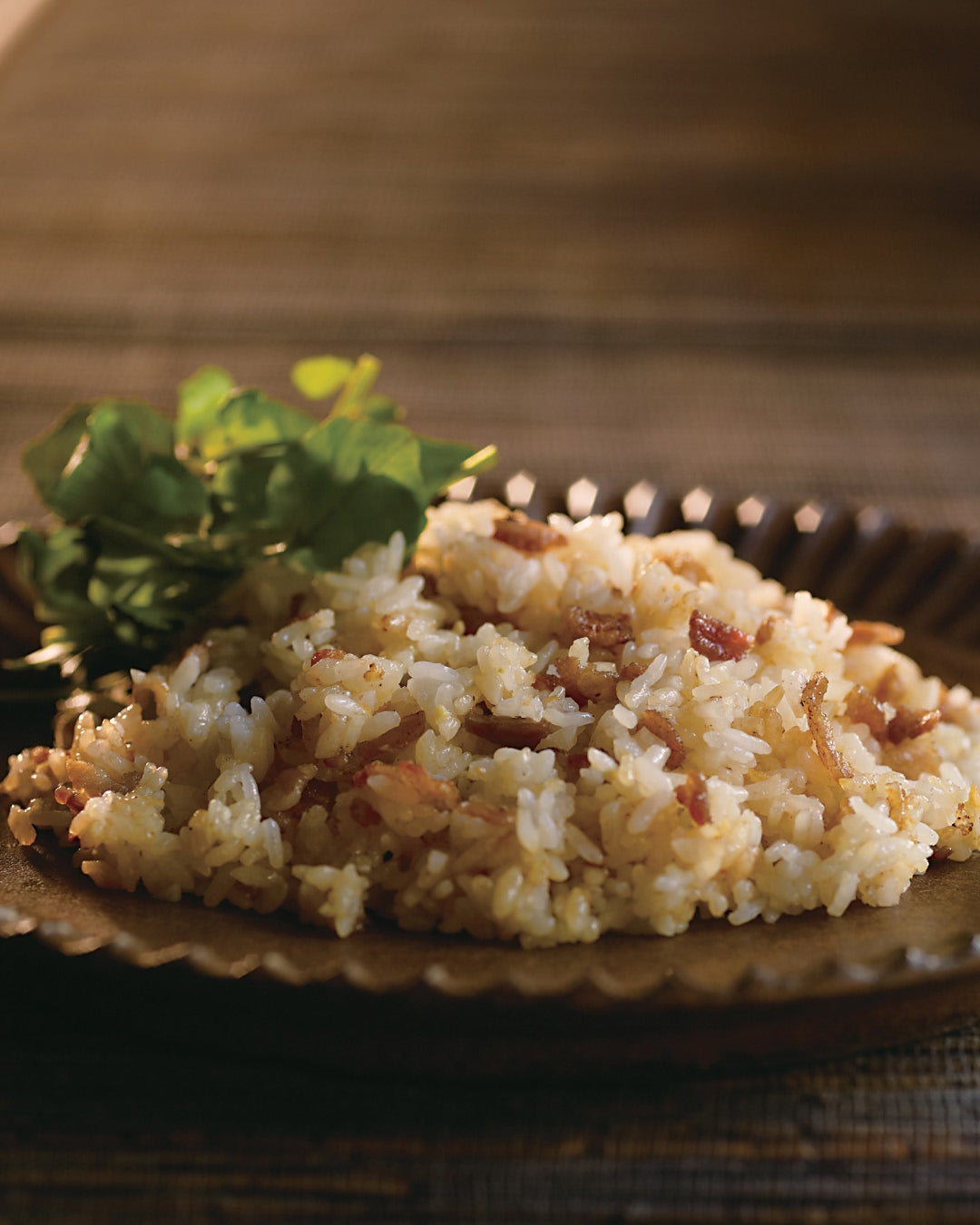 Japanese-style fried rice with pork and garlic, garnished with fresh herbs