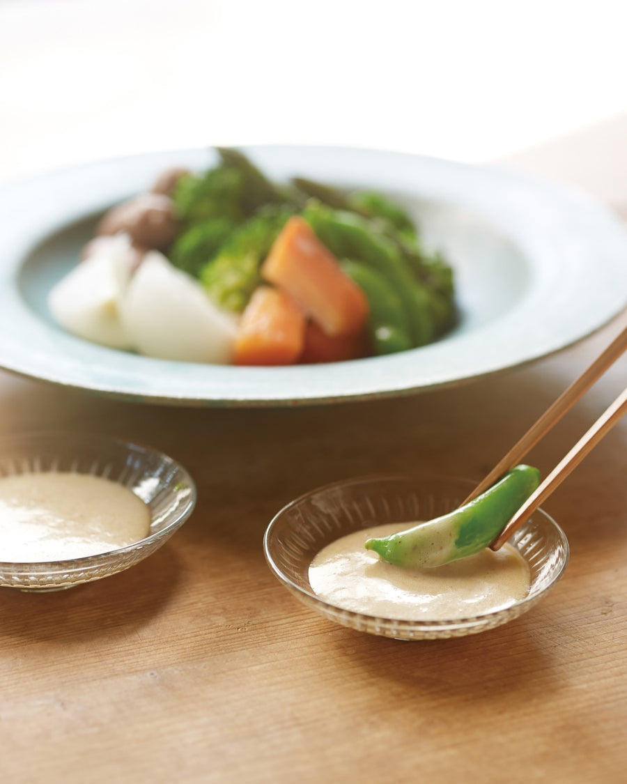 Fresh vegetables dipped in a creamy sauce, served in small glass bowls with chopsticks