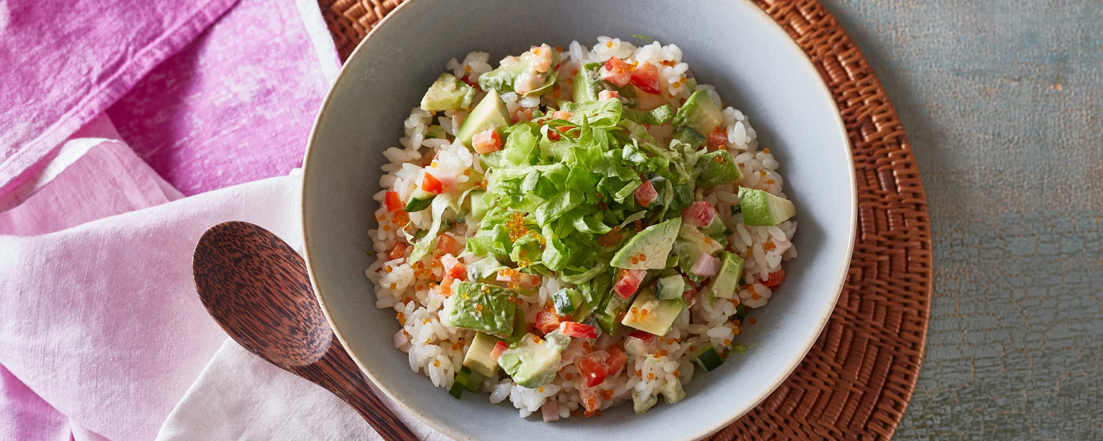 Avocado and vegetable mixed rice bowl topped with lettuce and tobiko