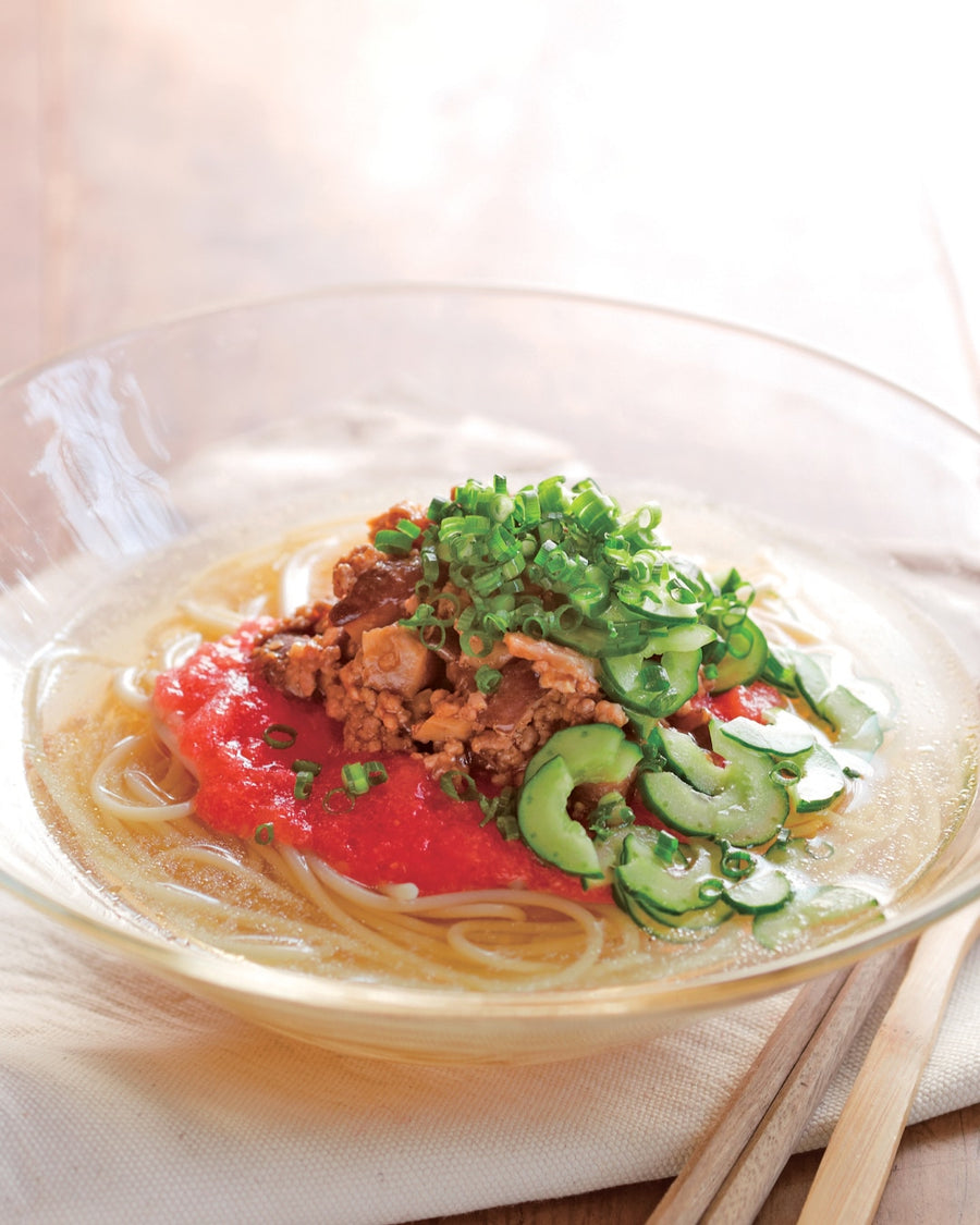 Chilled noodle soup with minced meat, mushroom, tomato, cucumber, and green onions in a clear broth