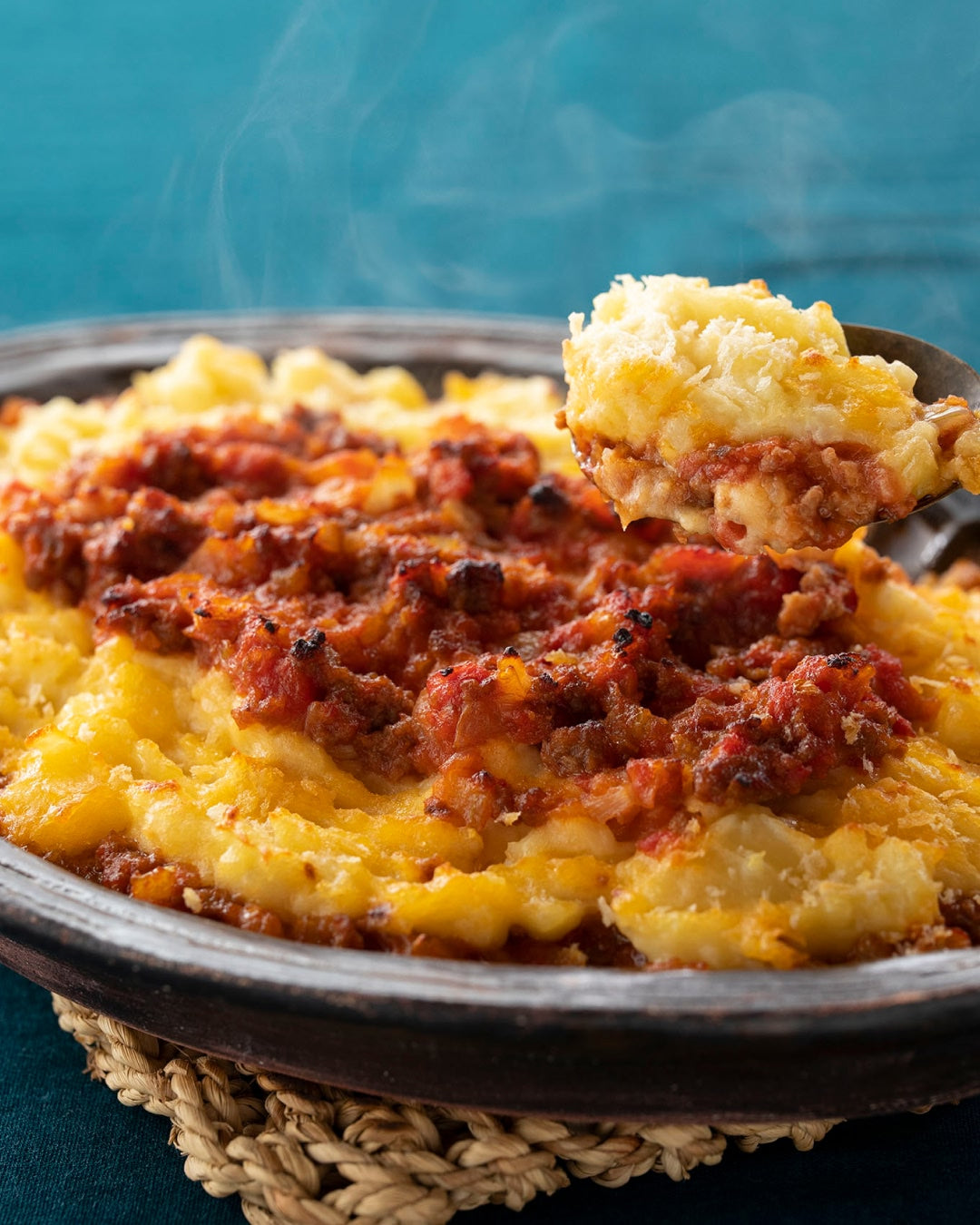 Baked mashed potato casserole with meat sauce, served in a dish.