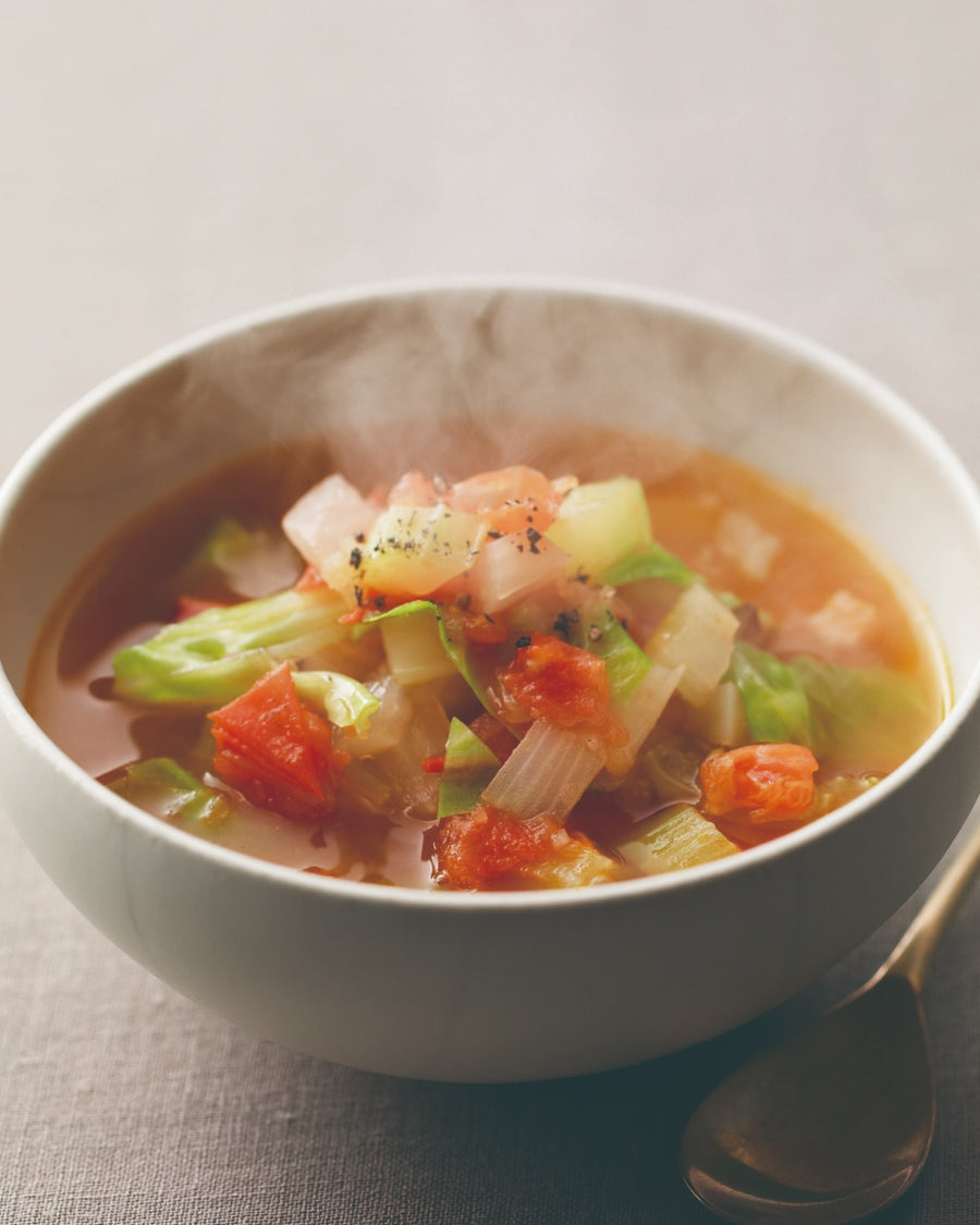 Hot vegetable soup with tomatoes, celery, and cabbage in a bowl.