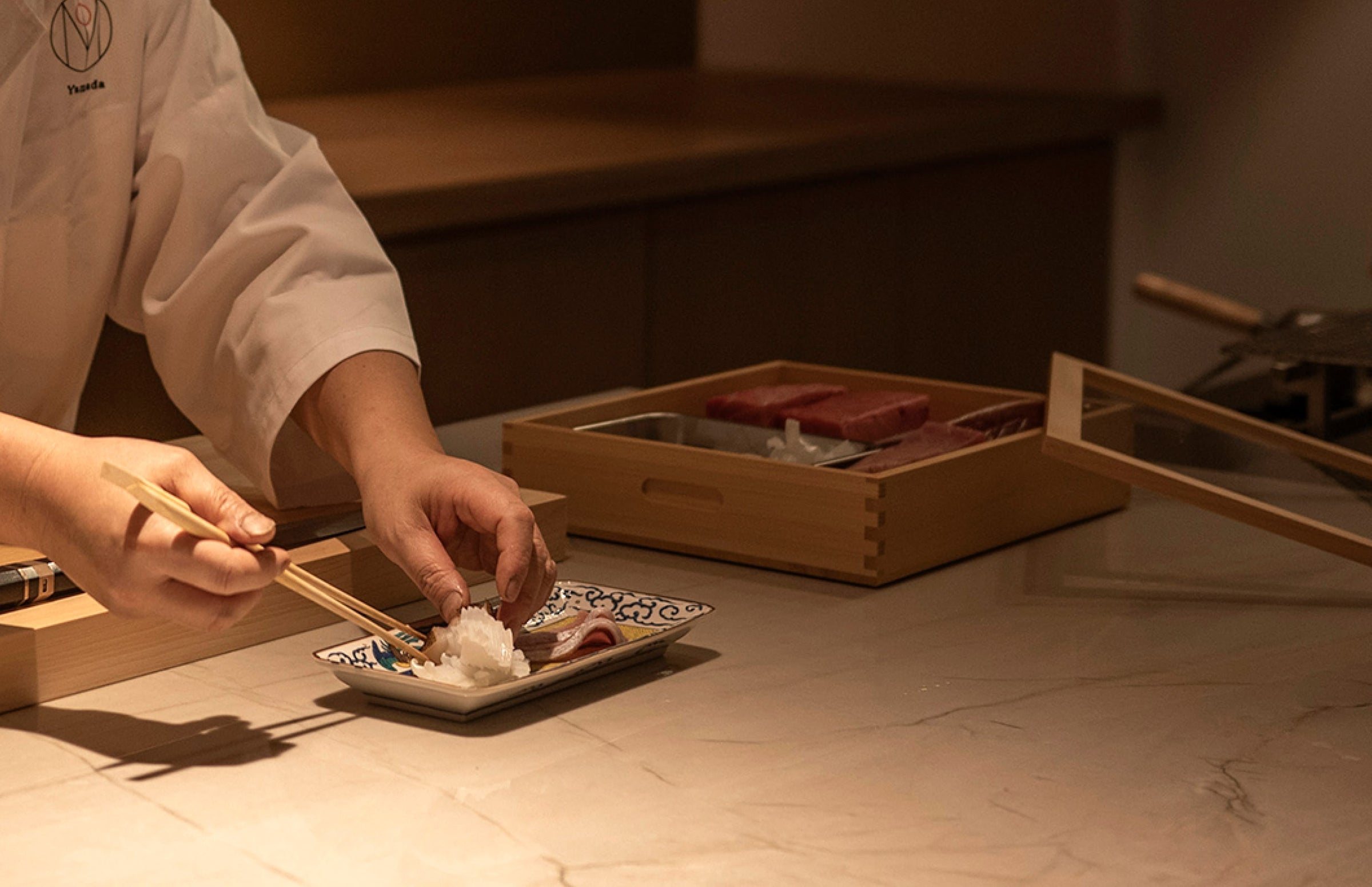 Chef plating a dish at a restaurant counter