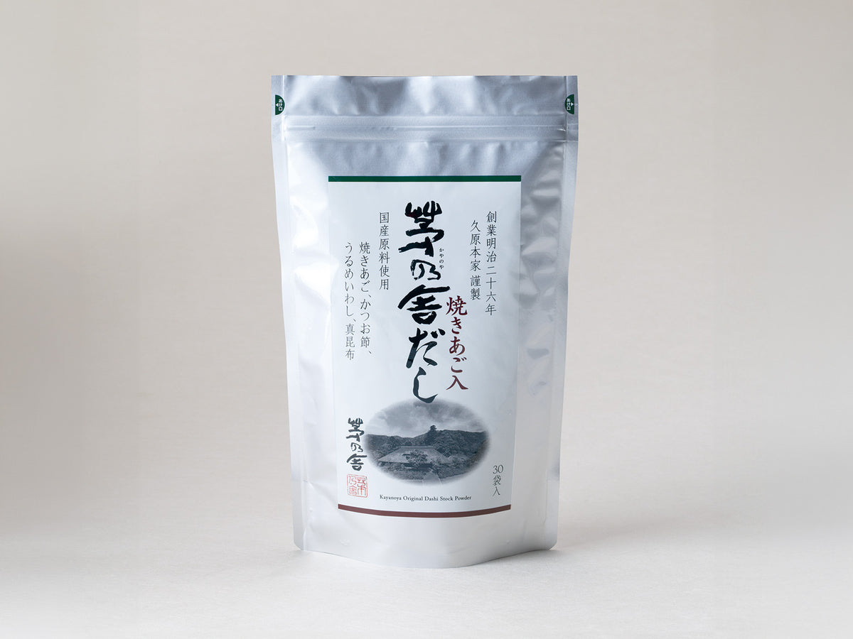 A white resealable pouch labeled with Japanese text and an illustration of a mountain, containing 30 sachets of Kamogawa Chagyo’s Sakyo no Dashi, a traditional Japanese soup stock product.